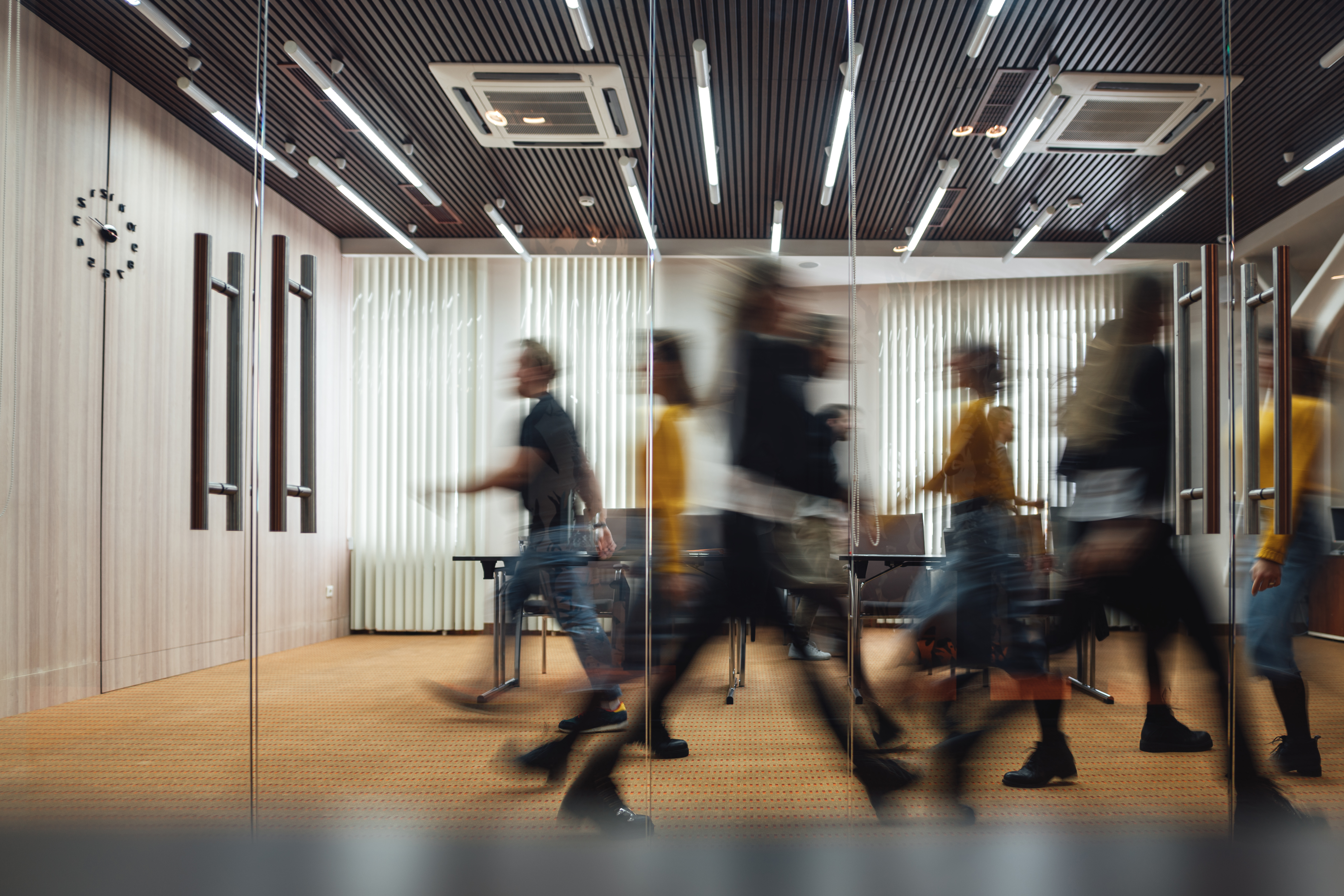 Employees walk quickly through a modern office space